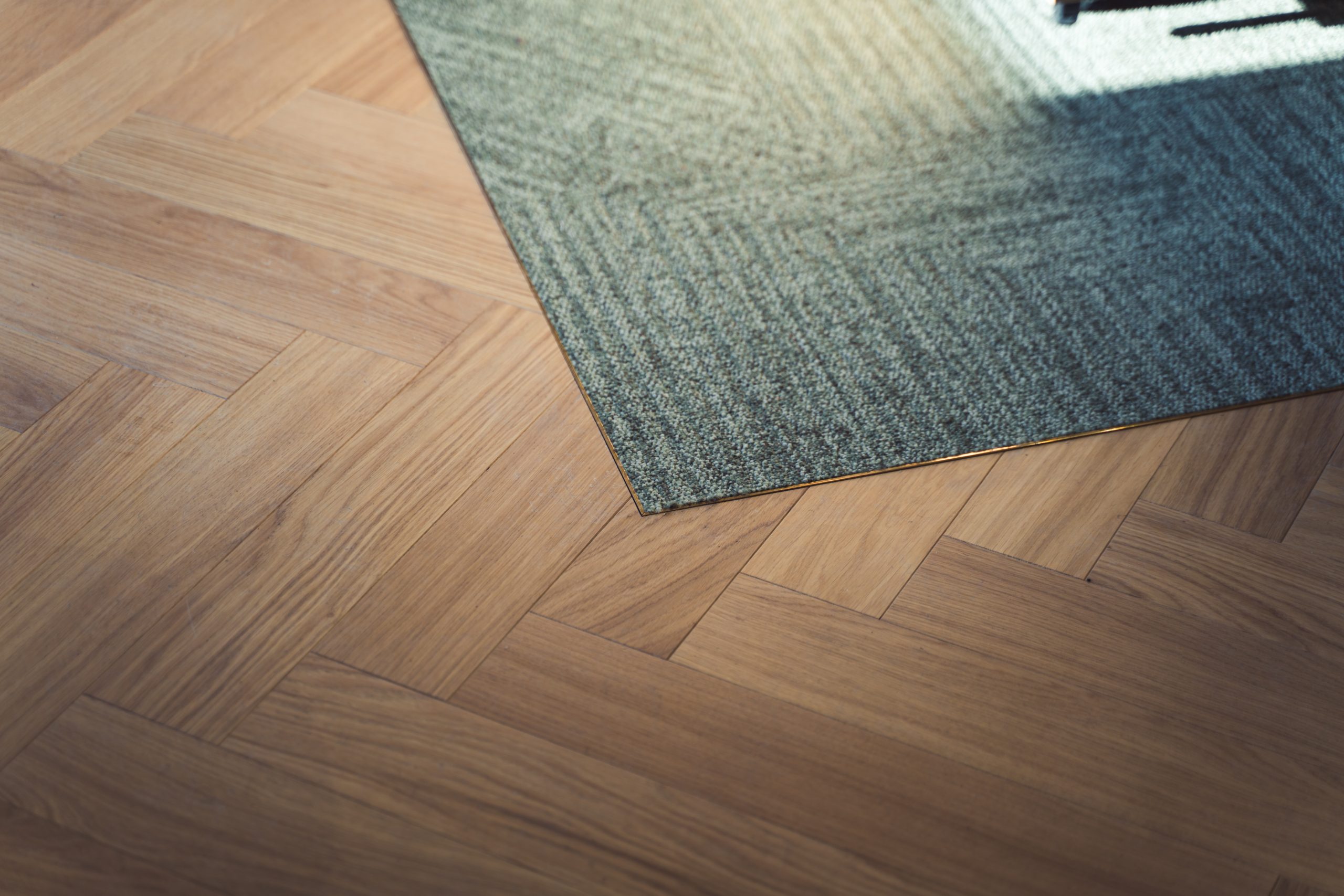 herringbone floor with greens and teal colour pops on carpet floor