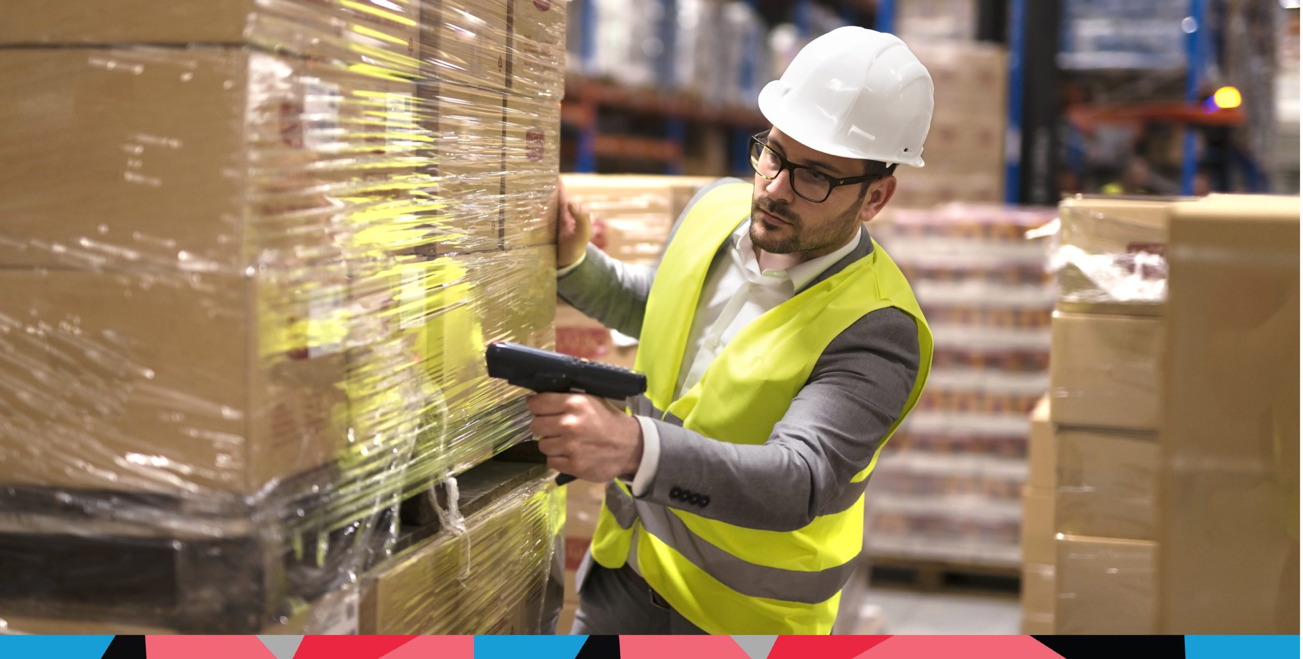 Warehouse operatives scanning a barcode on pallet of stock that links to the warehouse management system.