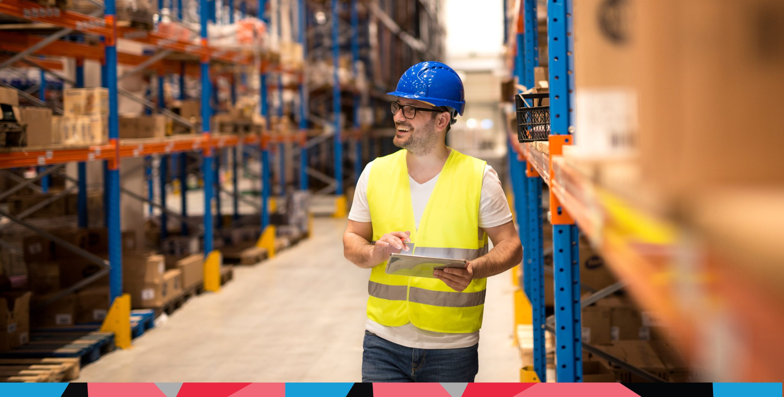 Warehouse operative standing in a warehouse pallet racking aisle with a picking list