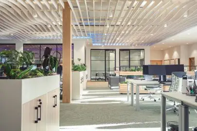 Modern executive jet support office with workstations, glass partitions, and lounge seating in a sleek, professional interior.