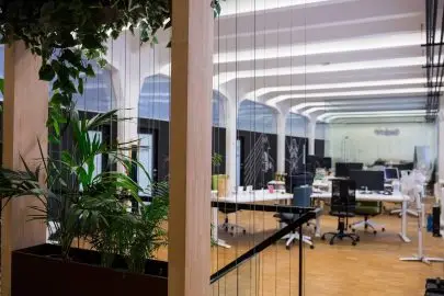 A bright, open-plan office space with modern workstations and large windows.
